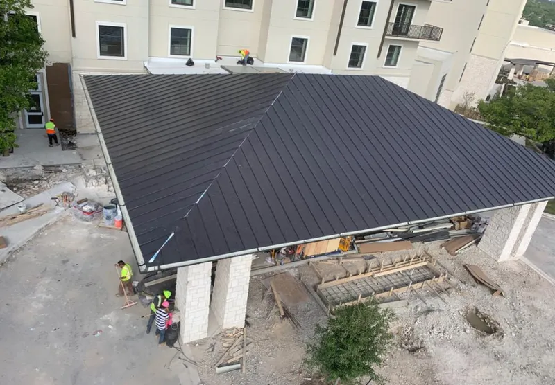Metal roofing installation team working on a commercial building in Naples Manor